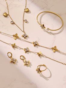 Multiple gold flower bracelets and necklaces spread out, ideal for professional wholesale stainless steel jewelry sourcing.