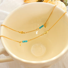 Soft styled shot of gold turquoise wing anklet in warm decor, layered look and vibrant turquoise accent for boho summer aesthetic