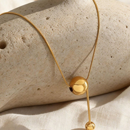 316L stainless steel gold ball tassel necklace flatlay with chic drop