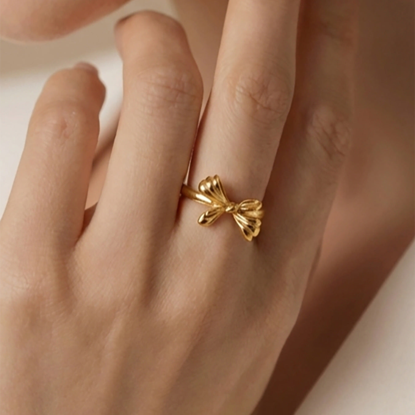 Chic bow open ring in stainless steel with gold PVD finish worn by model