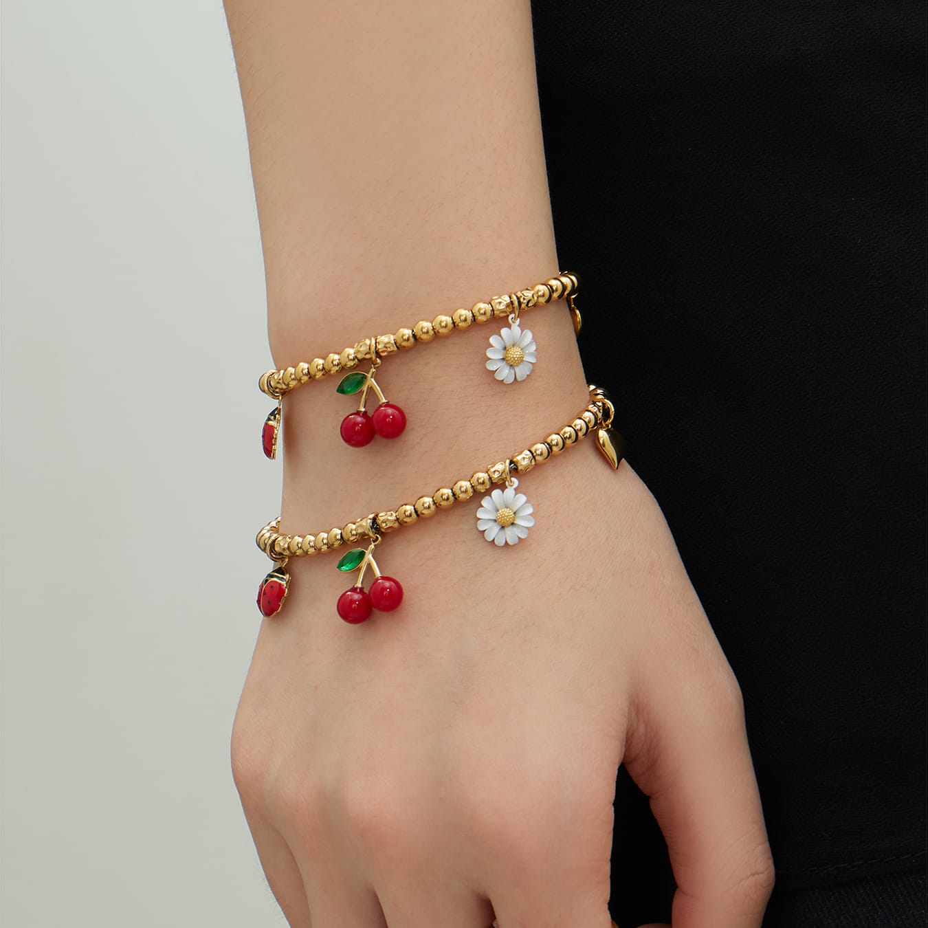 316L stainless steel cherry daisy charm bracelet worn on wrist lifestyle shot