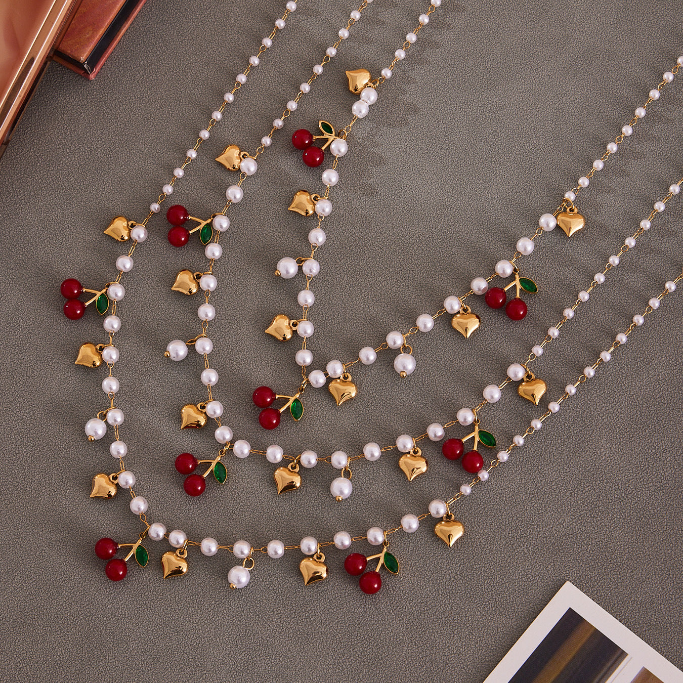 Artfully displayed heart and cherry jewelry pieces, demonstrating the versatility and playful elegance of the collection.