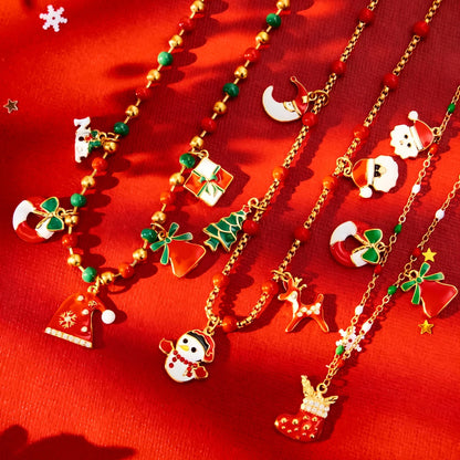 Flatlay of 316L stainless steel Christmas charm beaded necklace with enamel Santa snowman tree charms on festive red background