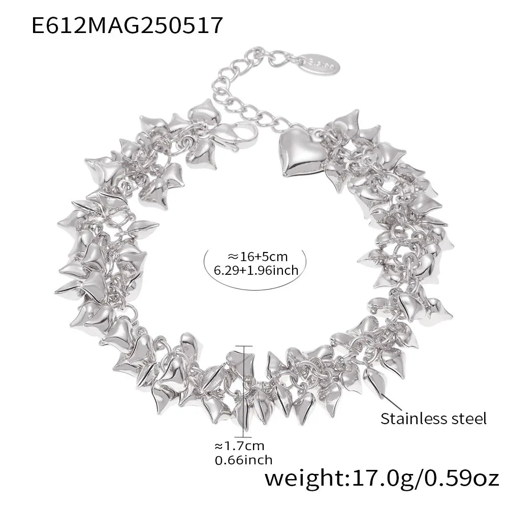 Steel-tone chunky heart charm bracelet close-up worn on wrist