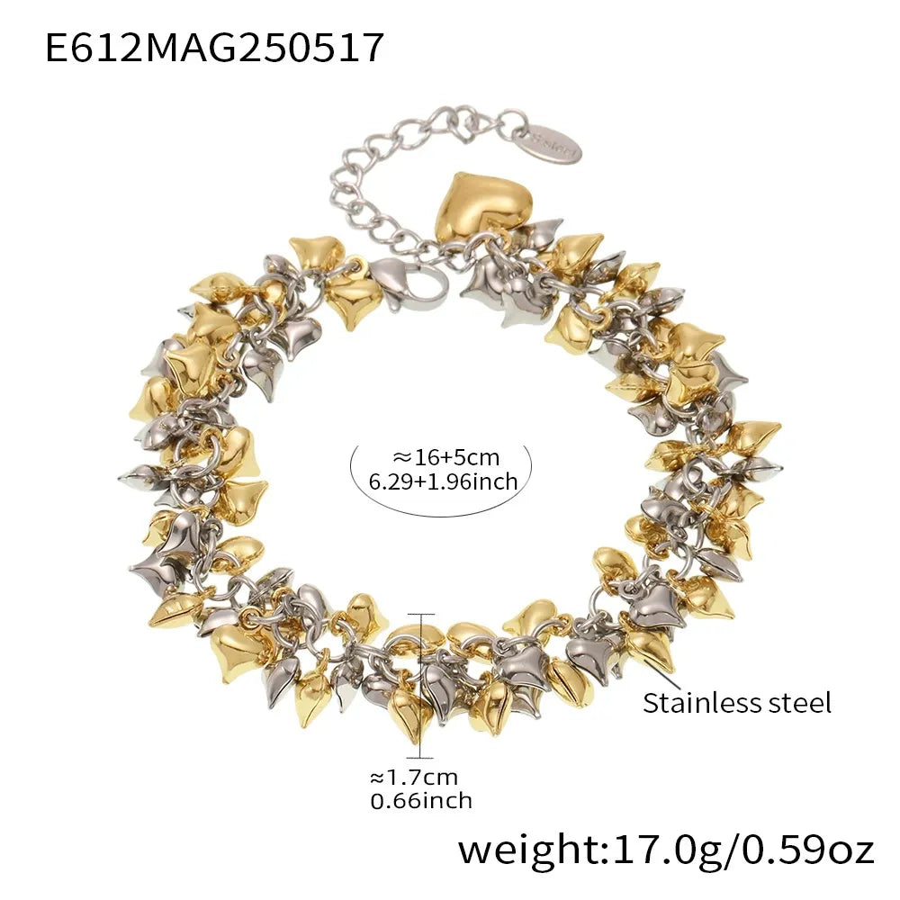 Chunky heart charm bracelets stacked in gold and steel tones for fashion jewelry editorial styling