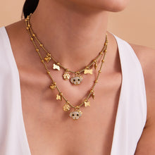 A woman wearing layered hypoallergenic dog and bone pendant necklaces with sparkling zircon on sensitive skin.