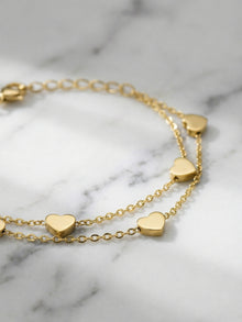 Hand wearing 316L stainless steel double layer heart chain bracelet, hypoallergenic for sensitive skin