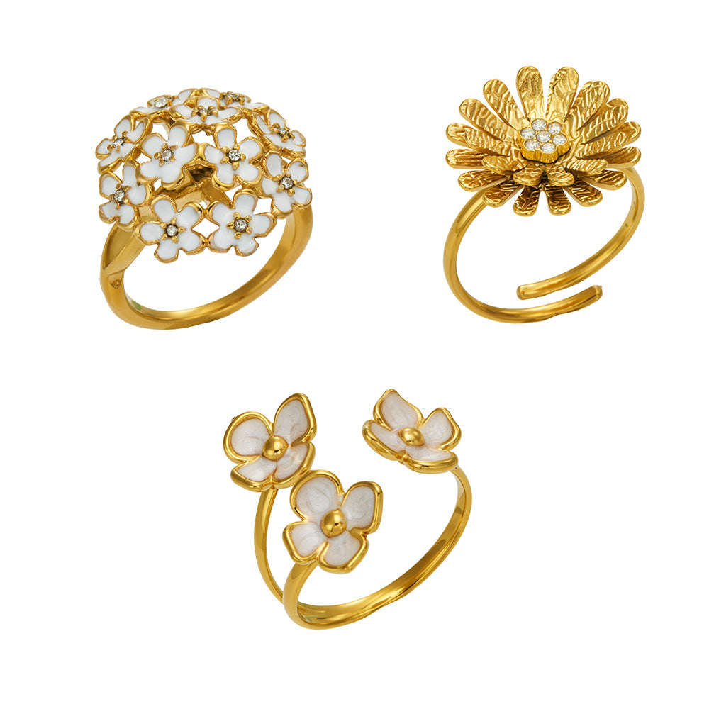 Collection of 316L stainless steel floral rings with daisy, enamel flower and cubic zirconia designs in 18K PVD gold