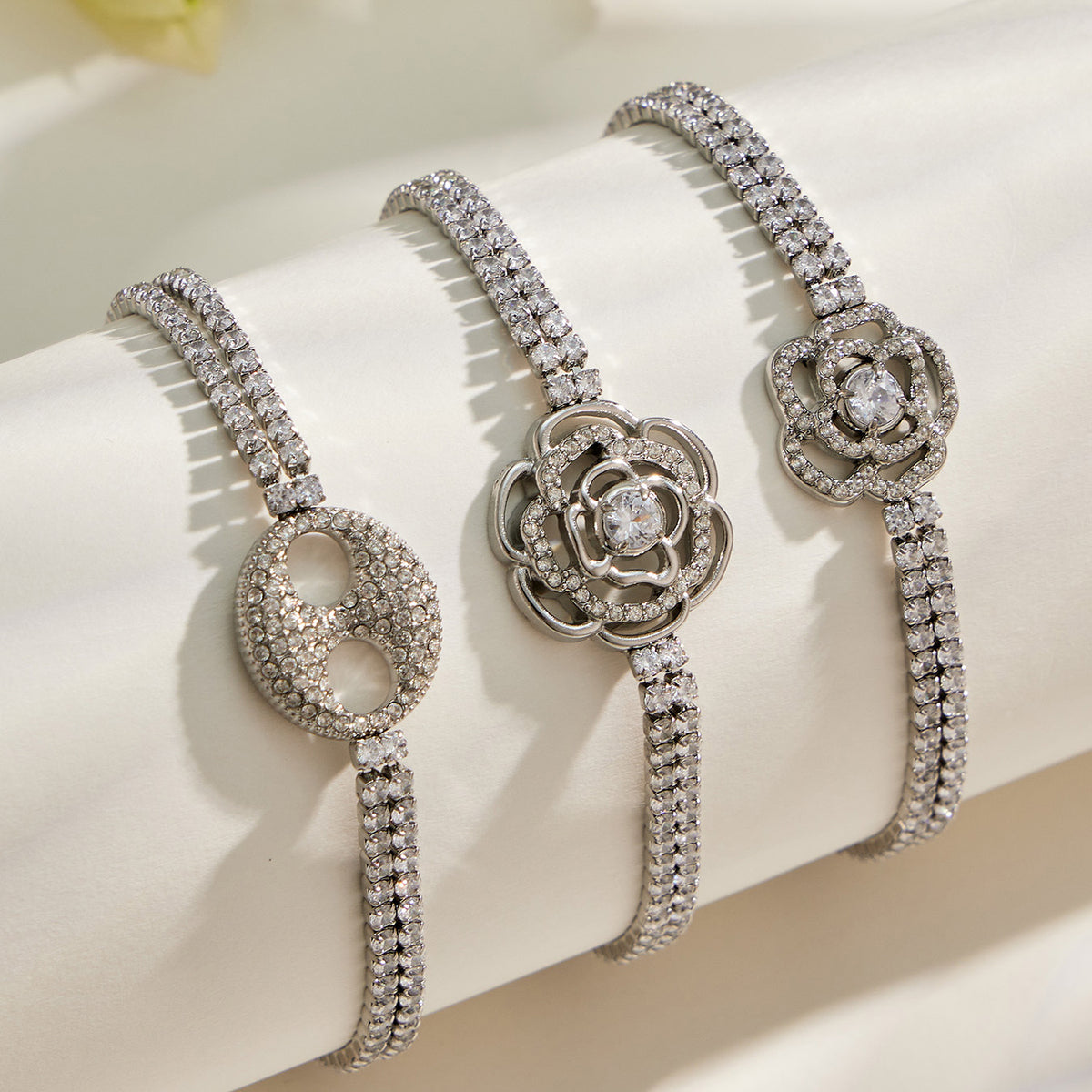 Three steel finish white zircon bracelets with decorative centerpiece designs