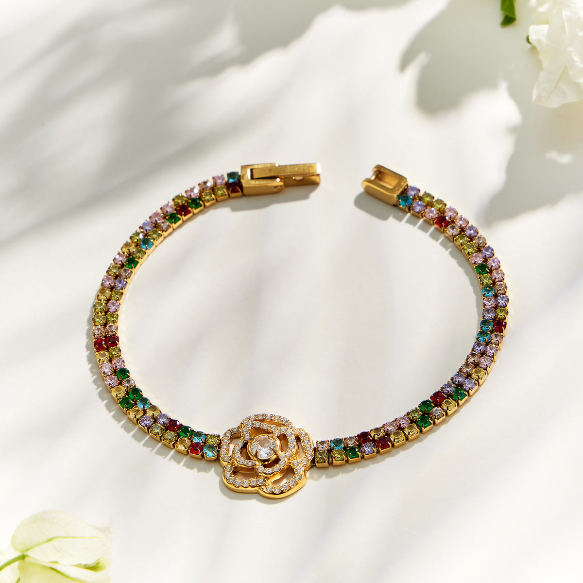 Multicolor zircon bracelet with a small flower centerpiece and gold finish
