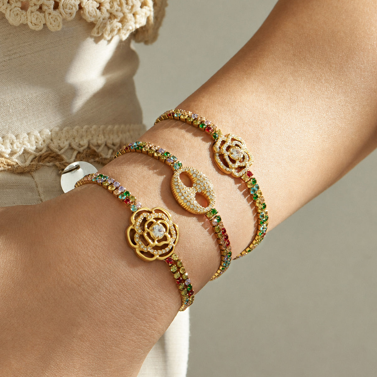 Multicolor zircon bracelets with floral and double-ring center motifs layered on the wrist