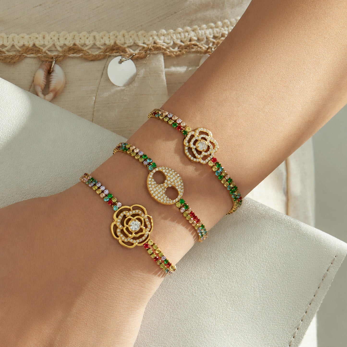 Gold finish multicolor zircon bracelets with three center designs worn together on the wrist