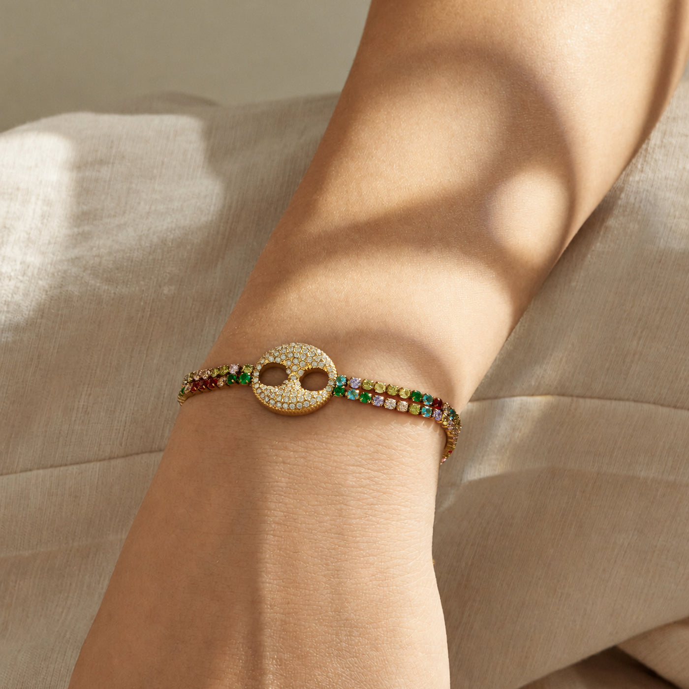 Multicolor zircon bracelet with double-ring center detail worn on the wrist