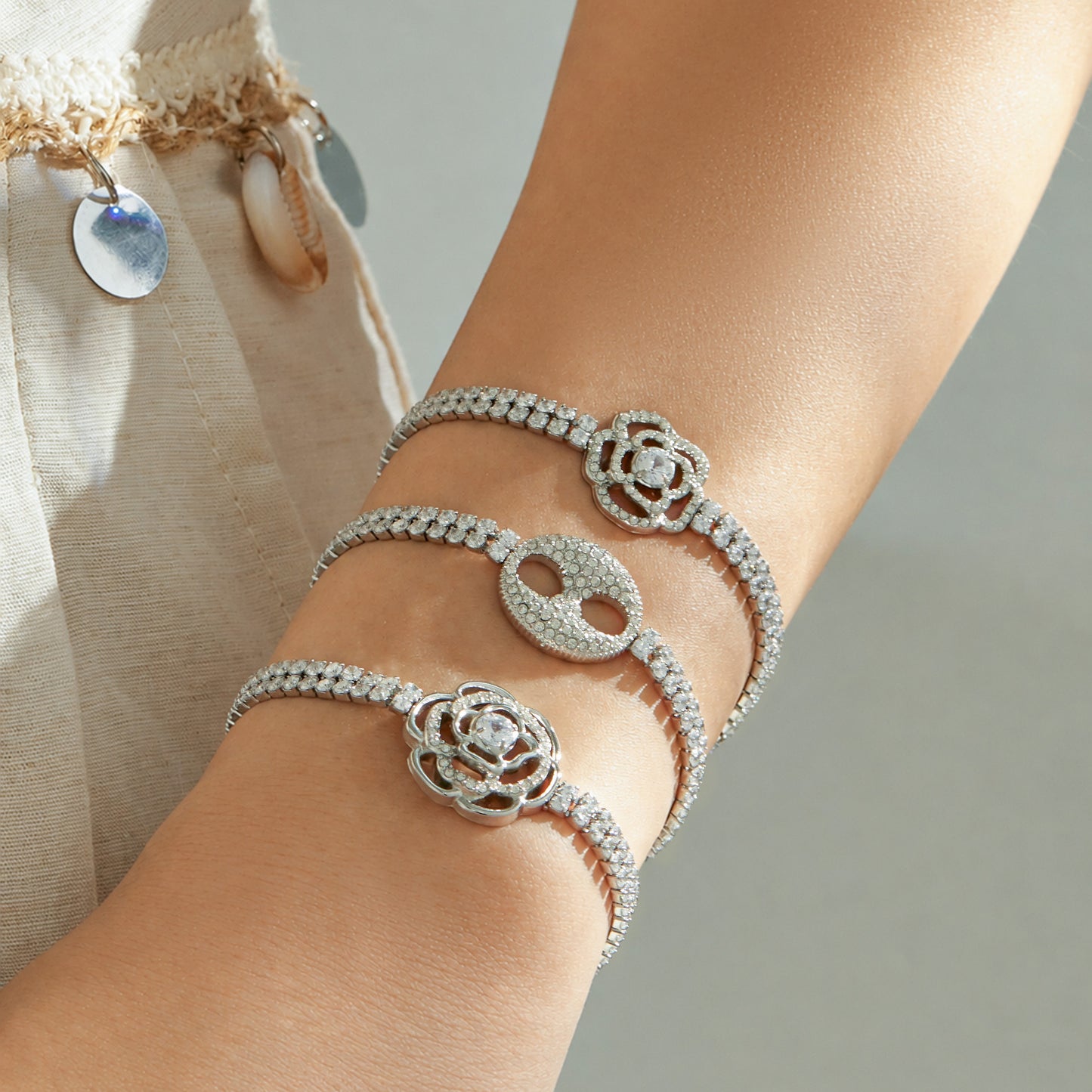 Three steel finish white zircon bracelets with floral and double-ring center designs