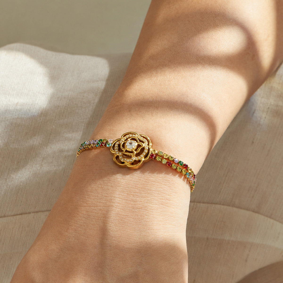 Multicolor zircon bracelet with a large flower centerpiece in gold finish