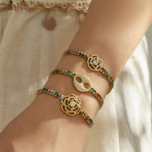 Three multicolor zircon bracelets in gold finish layered on the wrist