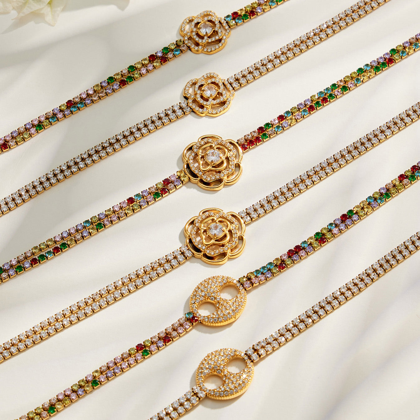 White and multicolor zircon bracelet designs displayed together with floral and double-ring centers