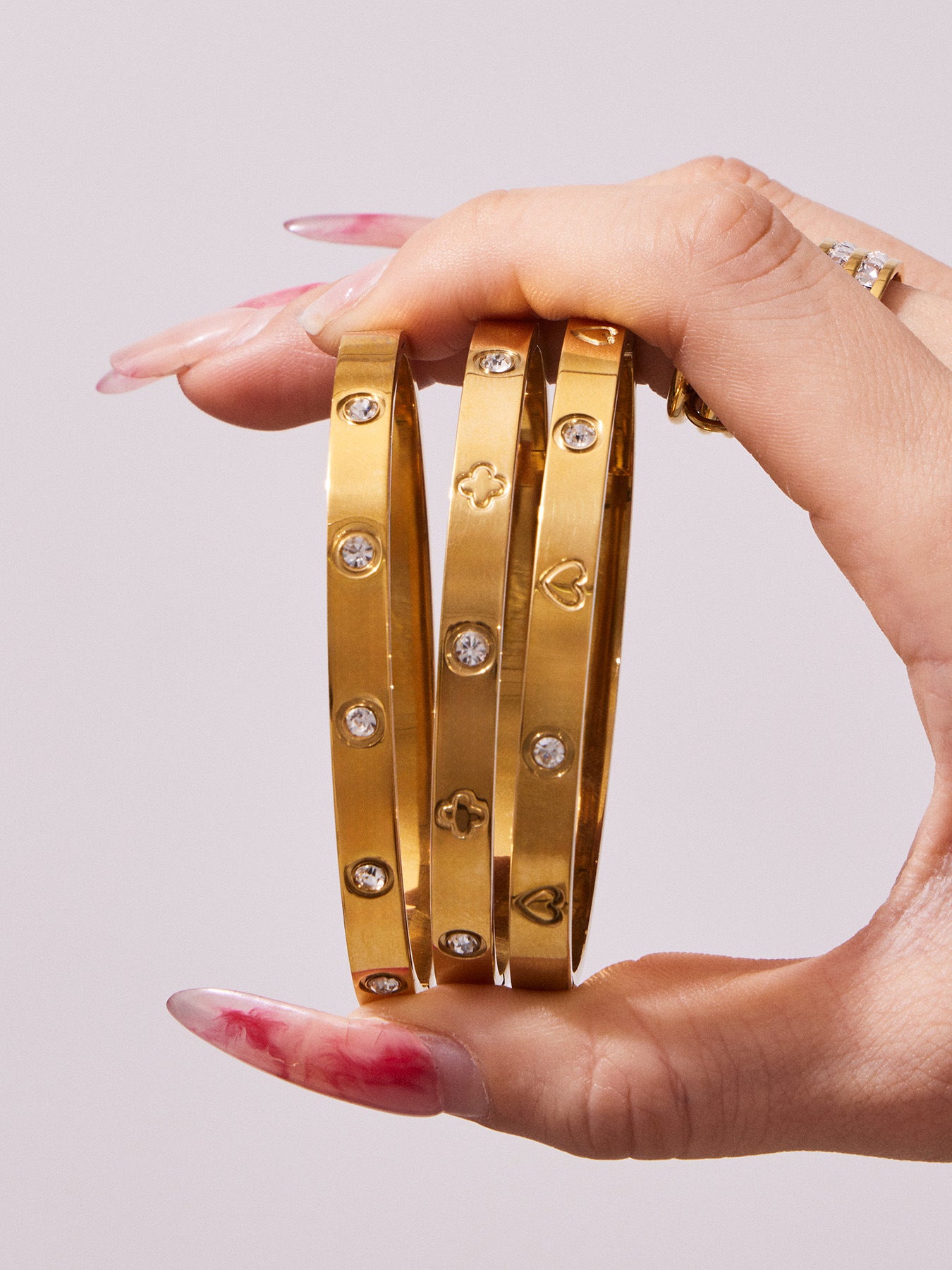 Slim 316L stainless steel gold bangles displayed together in the hand