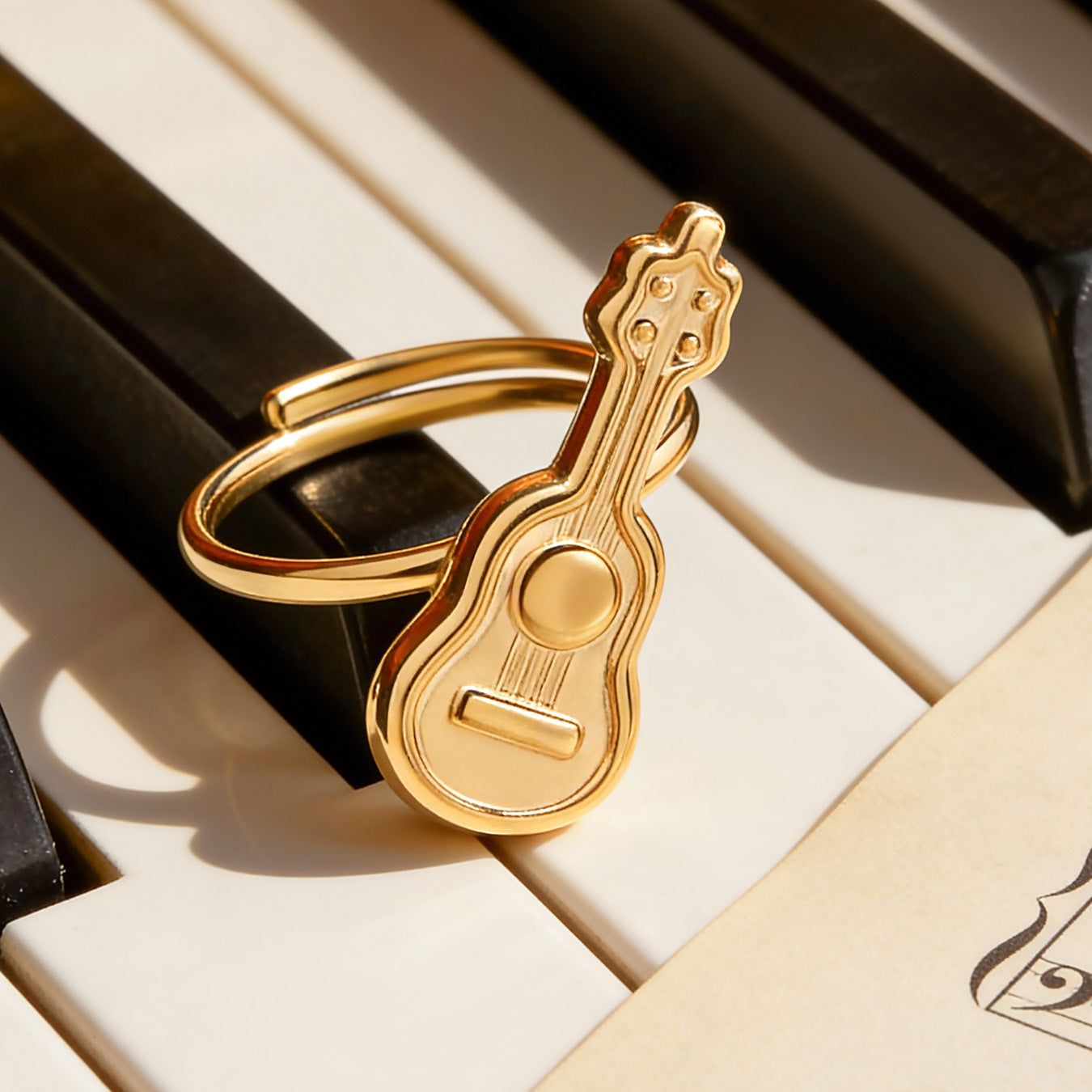 316L stainless steel guitar adjustable ring in gold finish styled with music-themed background