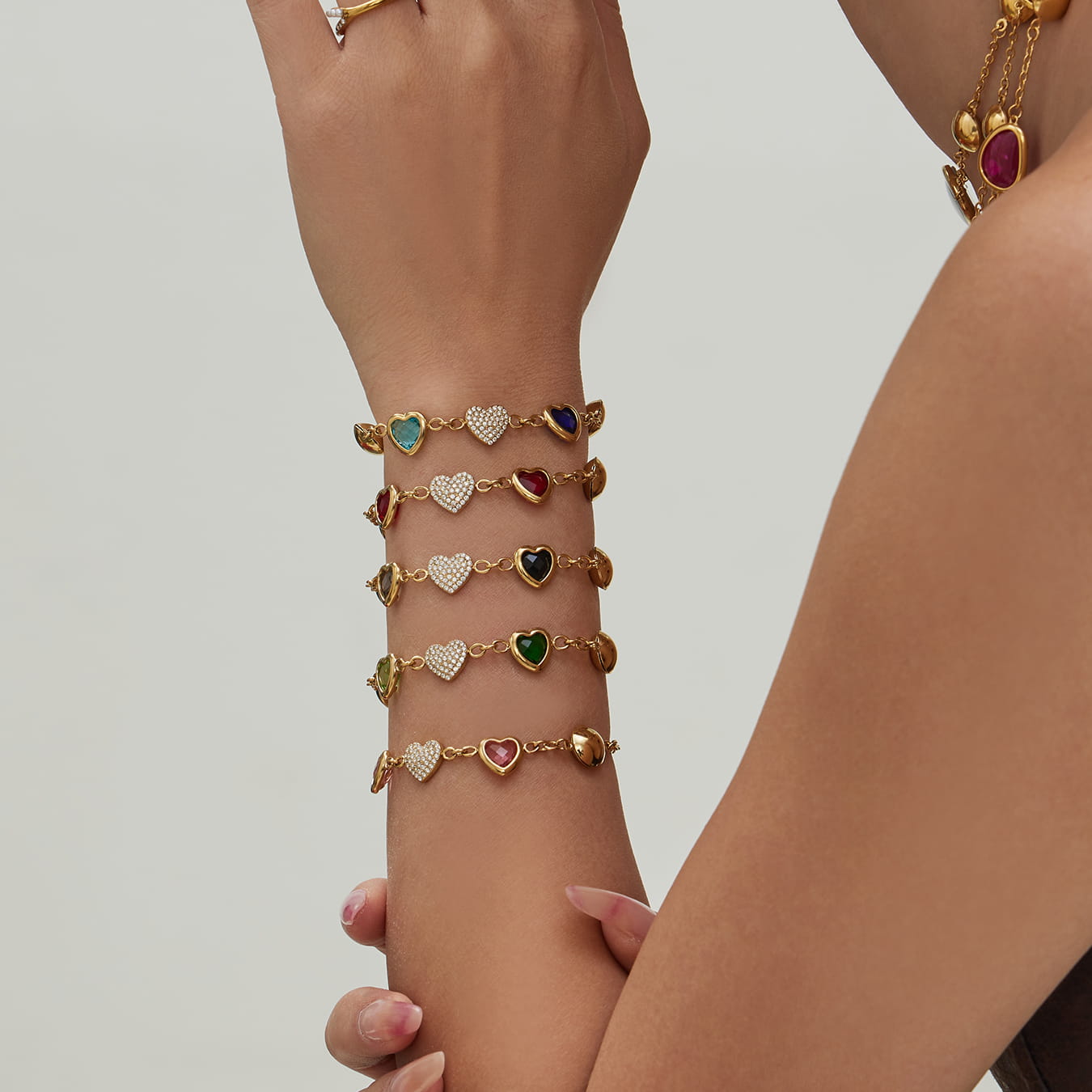 Vertical view of 316L stainless steel heart charm bracelets worn on arm for retail presentation