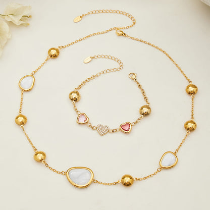 Flat lay of 316L stainless steel heart glass stone jewelry set in gold white and pink tones