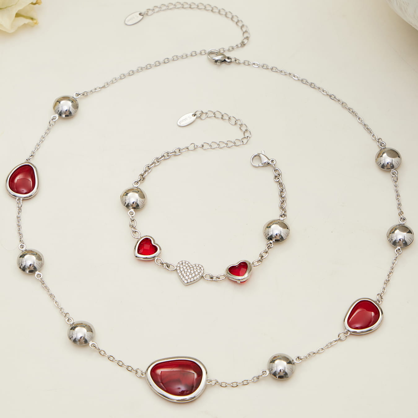 Flat lay of red heart glass stone jewelry set crafted from 316L stainless steel