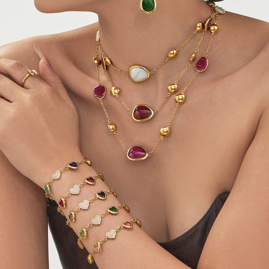 Model wearing 316L stainless steel glass stone necklace and heart charm bracelet set with gold finish