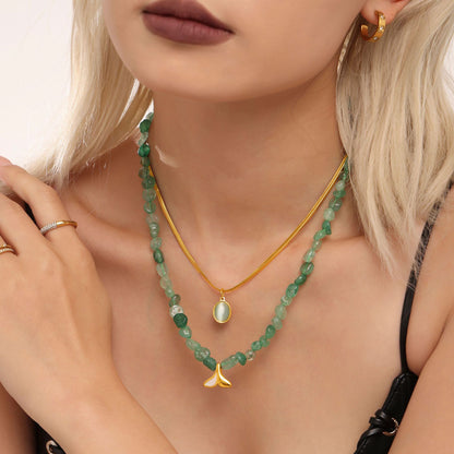 Collarbone view of 316L stainless steel layered necklace with green stone beads and gold aquamarine pendant