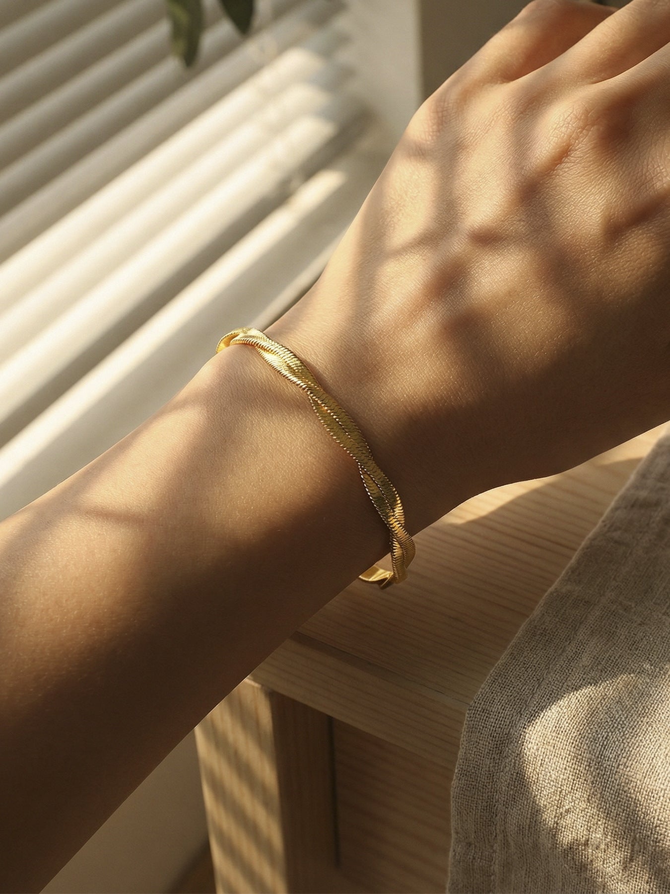 Model wearing 316L Stainless Steel minimalist blade chain bracelet, 18K gold PVD, elegant style