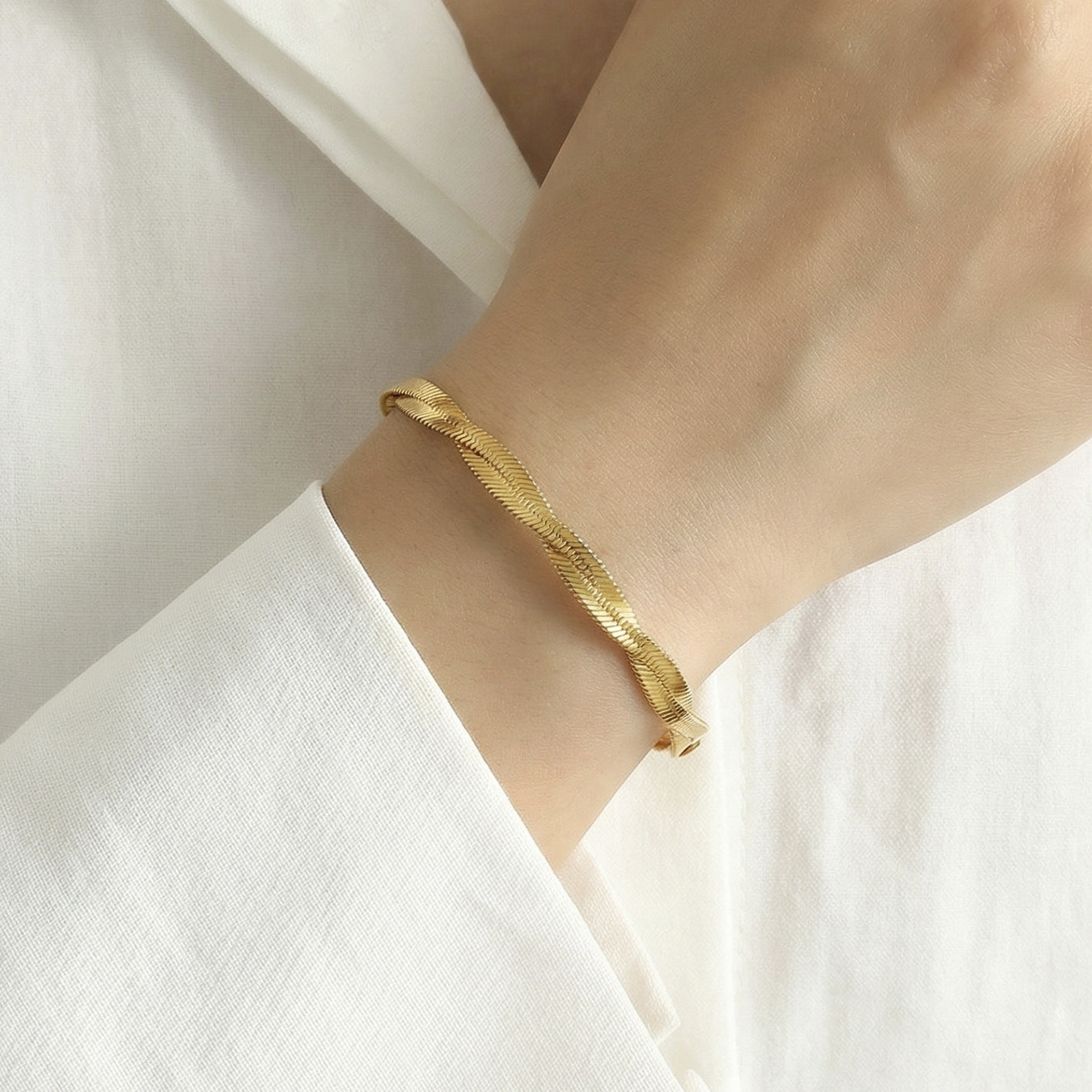 Hand wearing 316L Stainless Steel intertwined blade chain bracelet, 18K gold PVD plating
