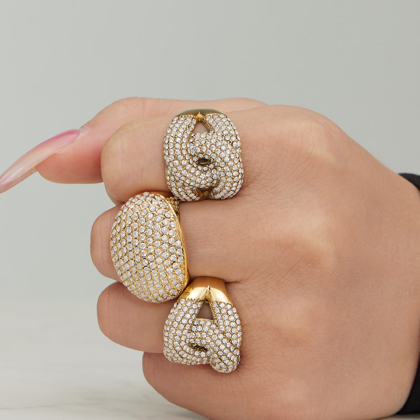 Model wearing 316L stainless steel pavé zircon statement rings in gold and steel tones for wholesale