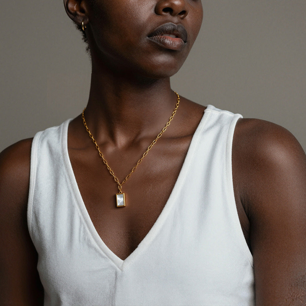 Close-up of 316L stainless steel seashell rectangle pendant necklace on model, paperclip chain