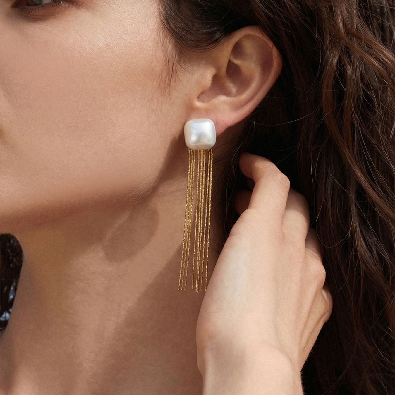 Model wearing steel tone 316L stainless steel shell bead tassel drop earrings in long tassel style