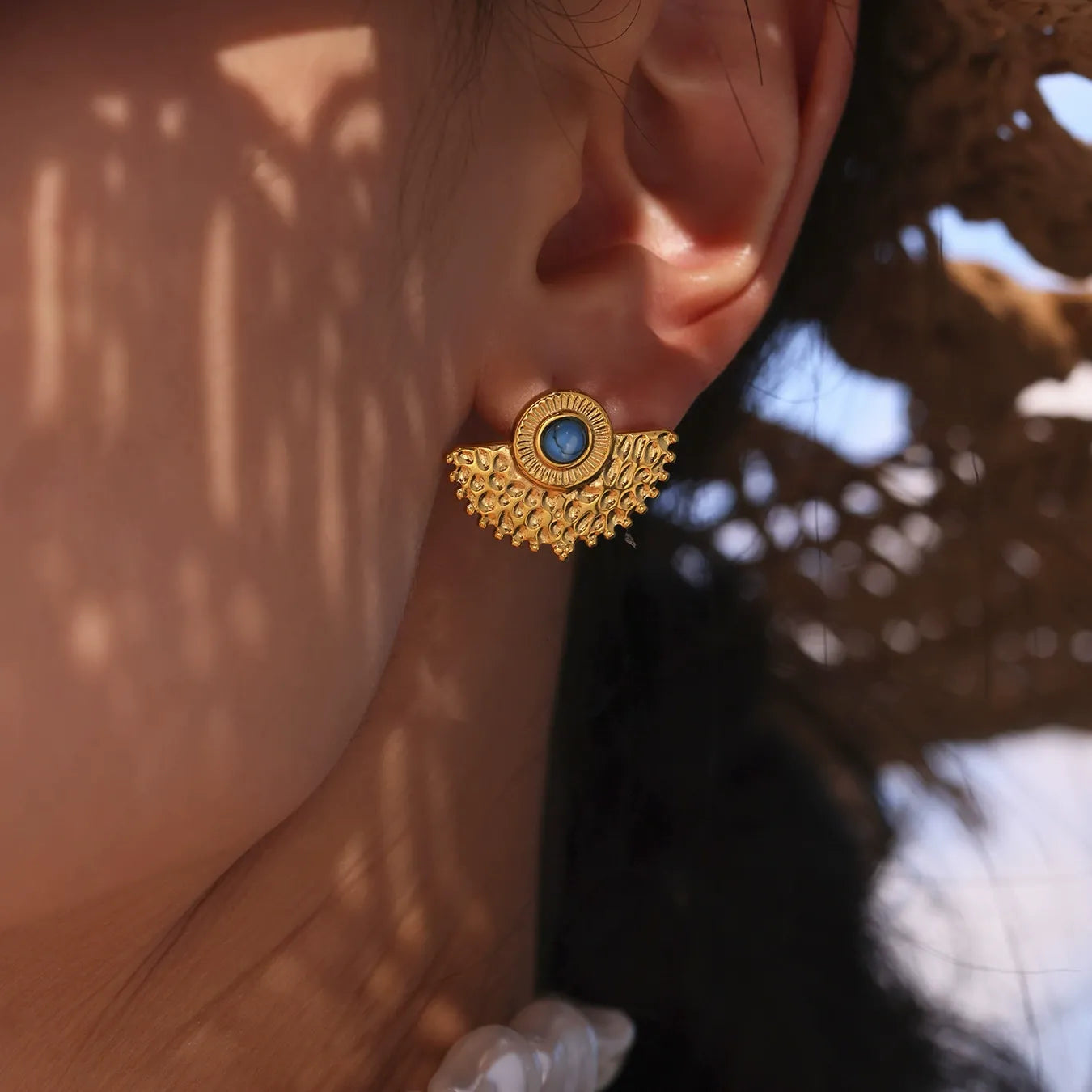 Gold turquoise statement stud earrings close-up on model