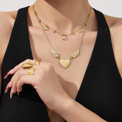 Model wearing 316L stainless steel zircon wing heart necklace with gold pvd finish