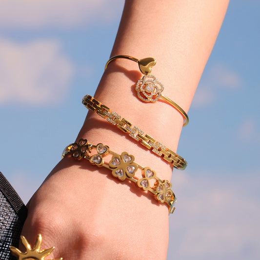 18k gold plated 5a zircon clasp bangle, layered on wrist against sky background