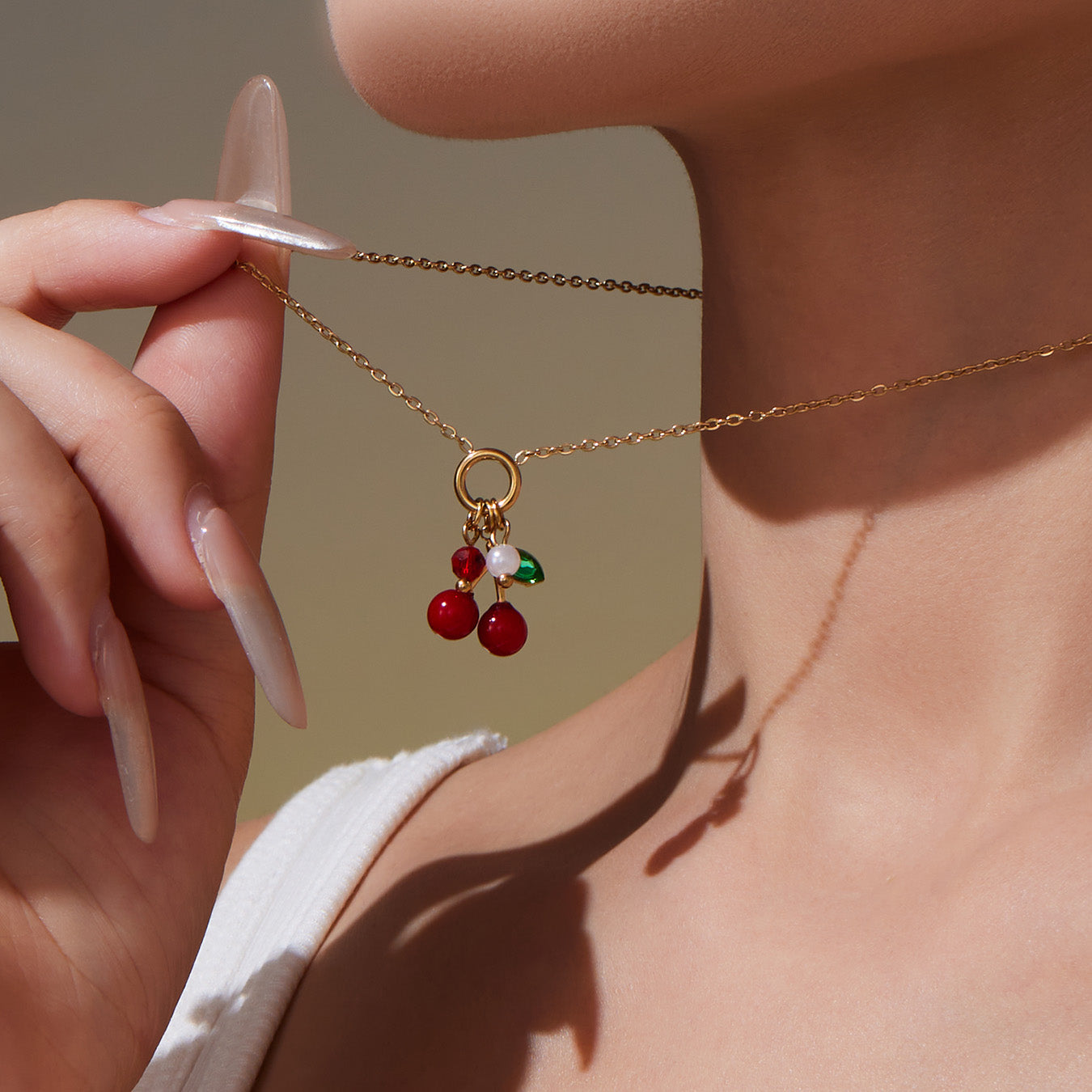 Model wearing 18k gold plated enamel red cherry necklace: zircon accent design