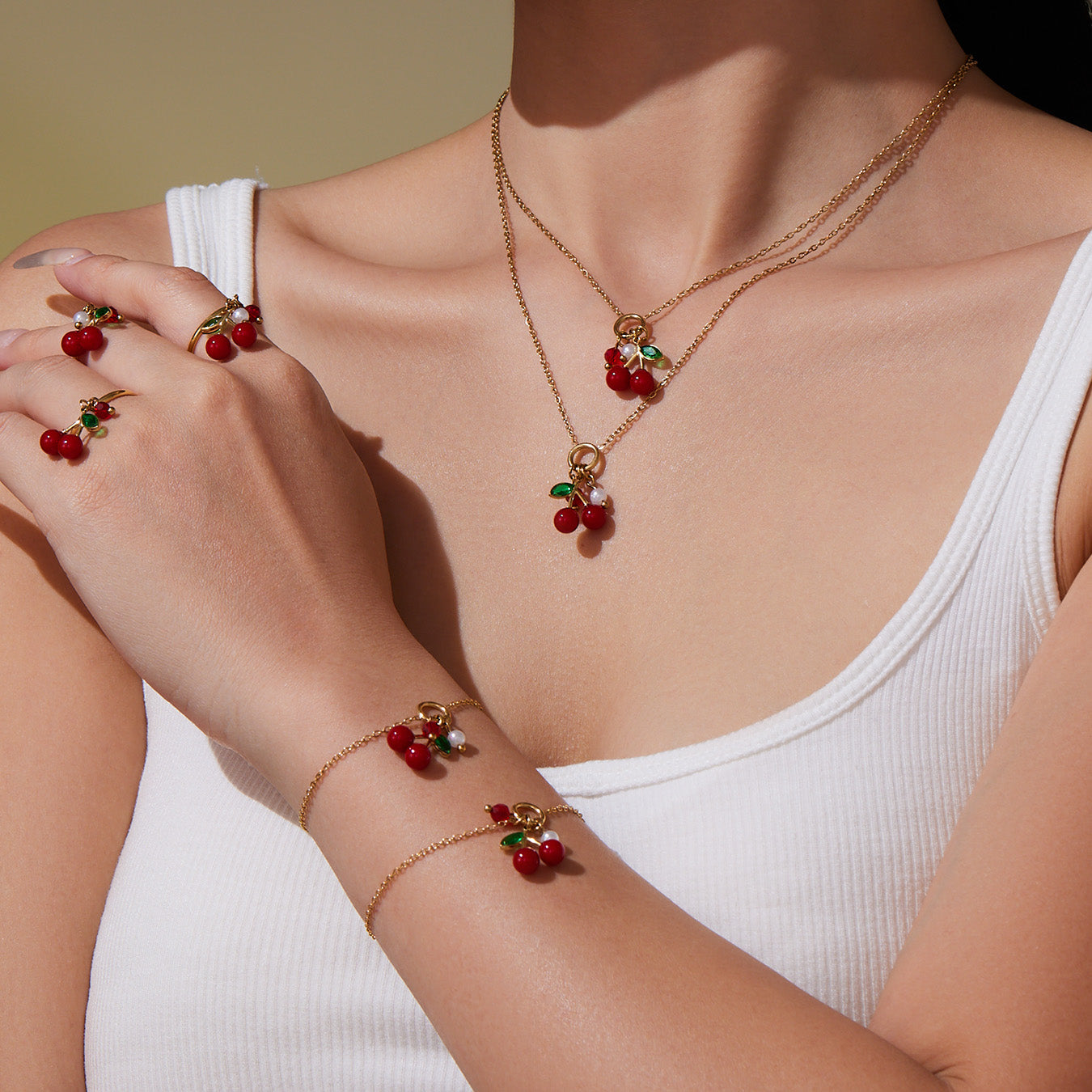Model wearing full 18k gold plated enamel red cherry jewelry set: necklace bracelet ring bangle
