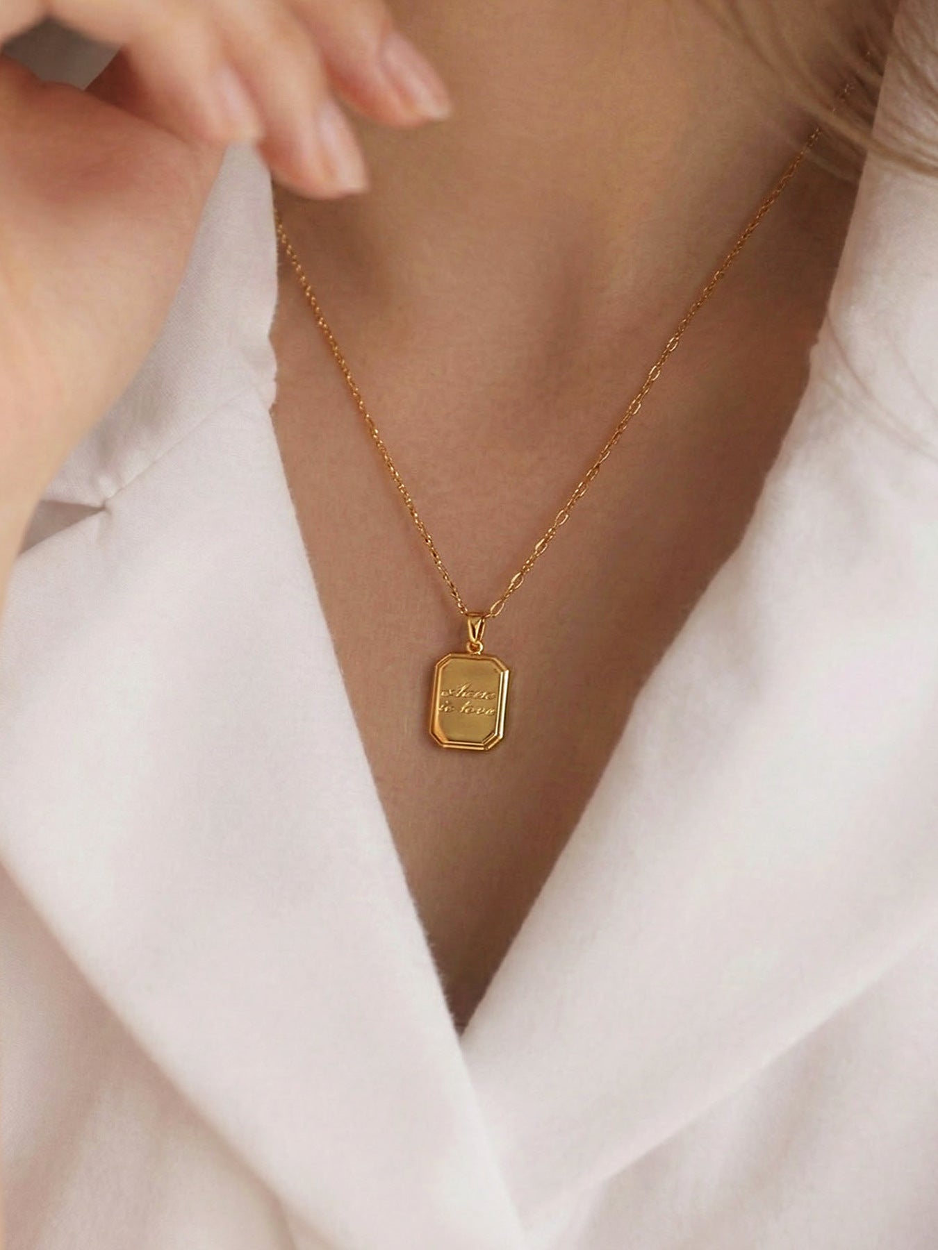  Model wearing minimalist gold square tag necklace with engraved "where is love", 316L stainless steel waterproof dual chain design, dainty everyday jewelry