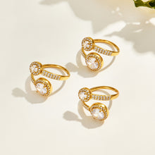 Three gold-tone stainless steel double halo rings displayed at different angles, showing the round stone settings and open bands