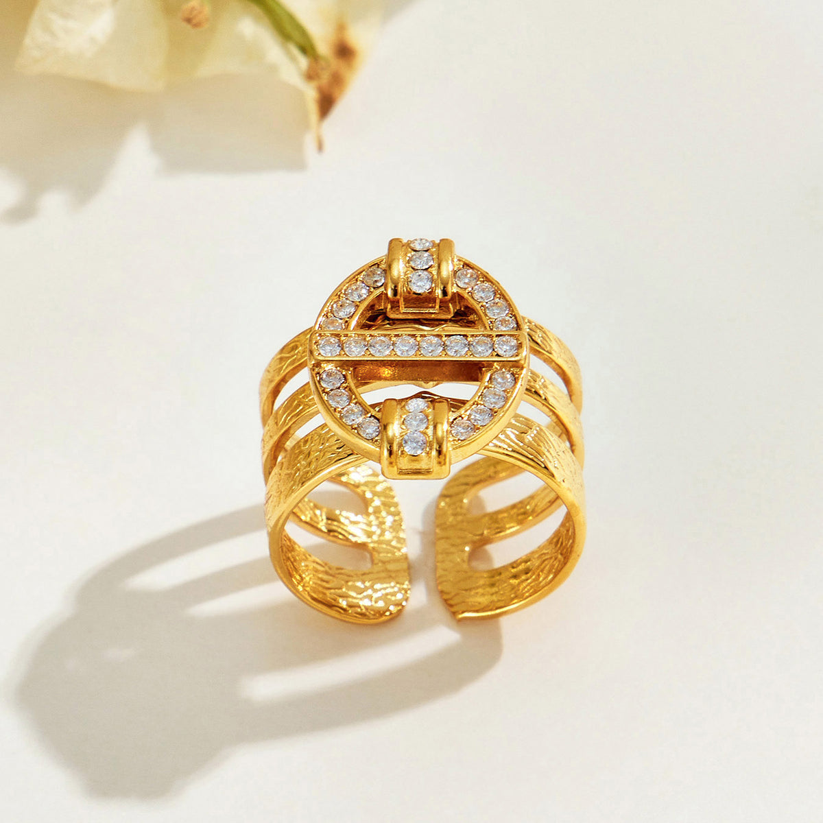 Front view of the A413 gold-tone stainless steel ring highlighting its geometric openwork design and clear stone accents