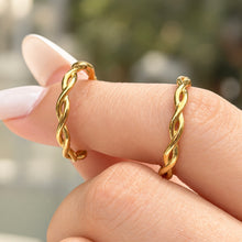 Two A451 gold-tone stainless steel twisted band rings displayed on a finger, showing their polished stone-free design