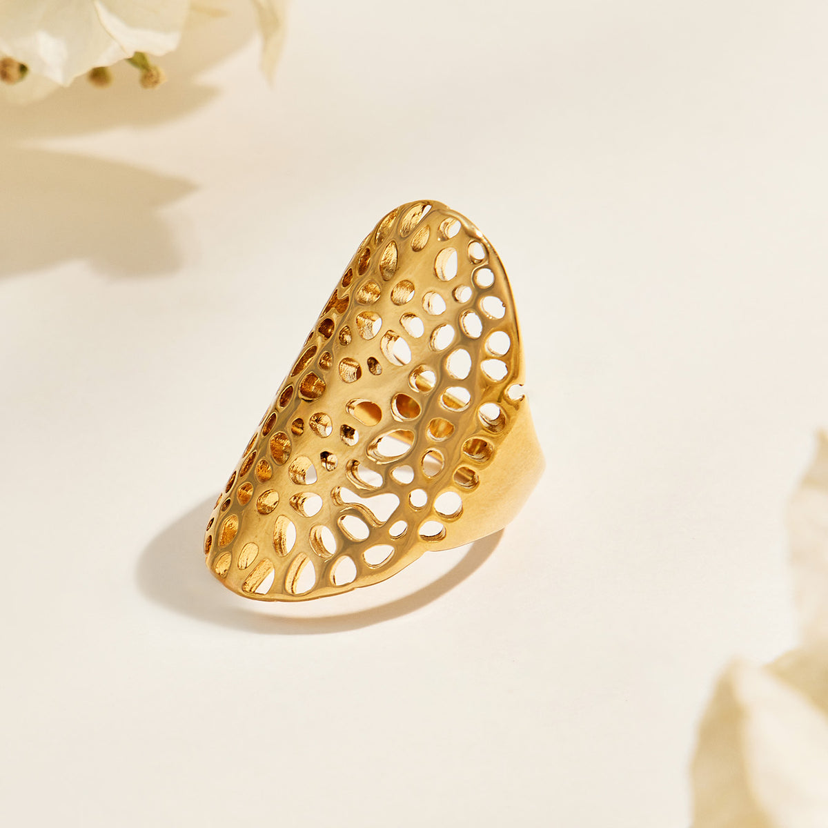 A582 gold-tone stainless steel statement ring with an elongated oval face and irregular openwork cutouts