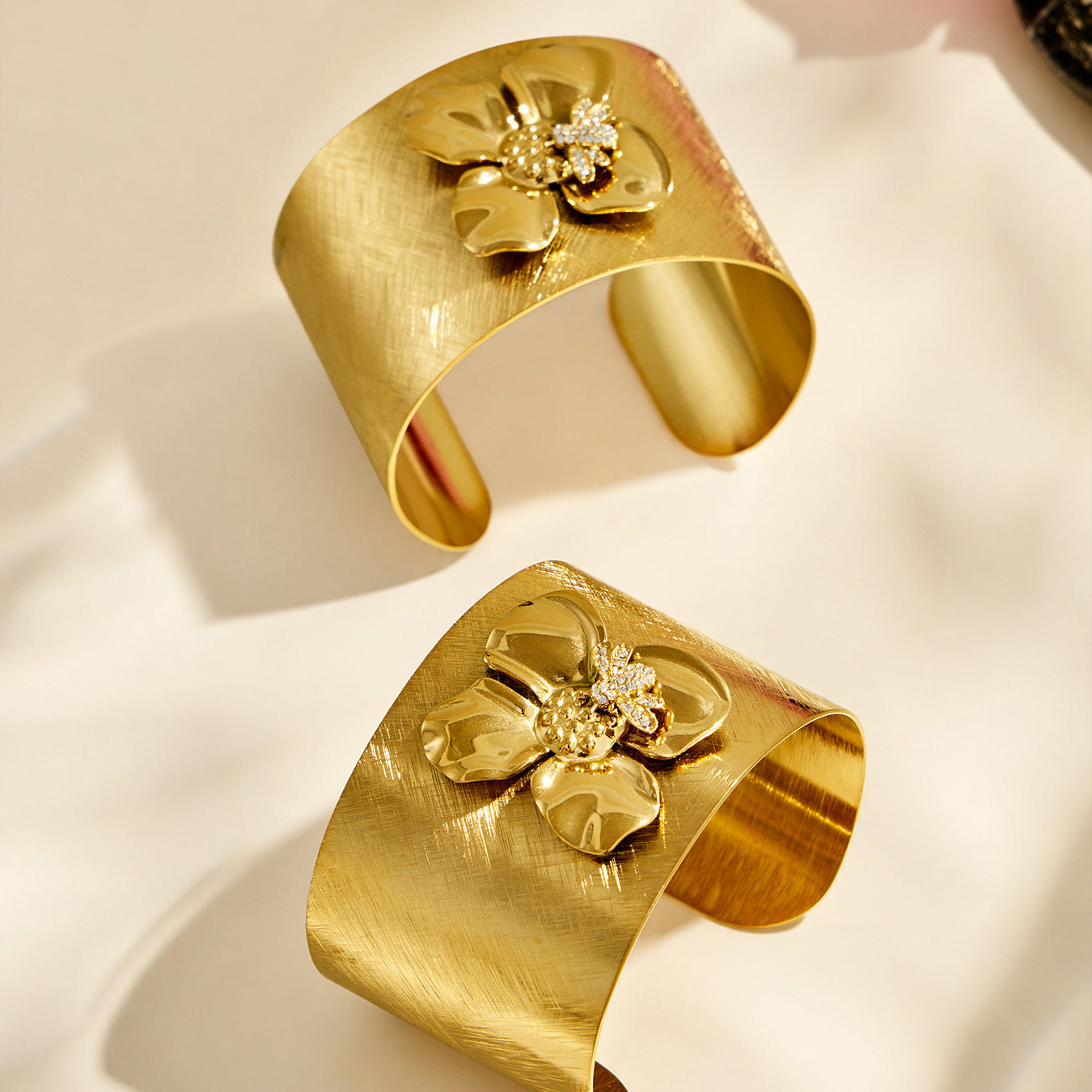 Front and angled views of a gold bee flower cuff bracelet with zircon details