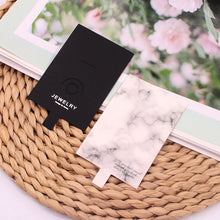 Black and white ring display cards styled together on a woven basket background