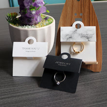 Black and white ring display cards arranged together for jewelry retail presentation