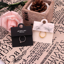 Black and white ring display cards styled with rings for boutique jewelry packaging