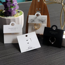 Black and white ring display cards used for retail jewelry presentation