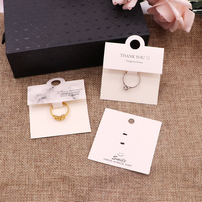 White and black ring packaging cards displayed together with rings