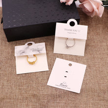 White and black ring packaging cards displayed together with rings